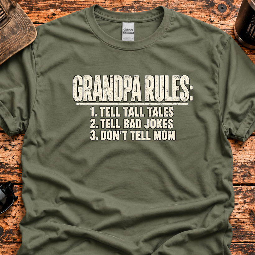 An olive green t-shirt with a white graphic print reading 'GRANDPA RULES: 1. TELL TALL TALES 2.
