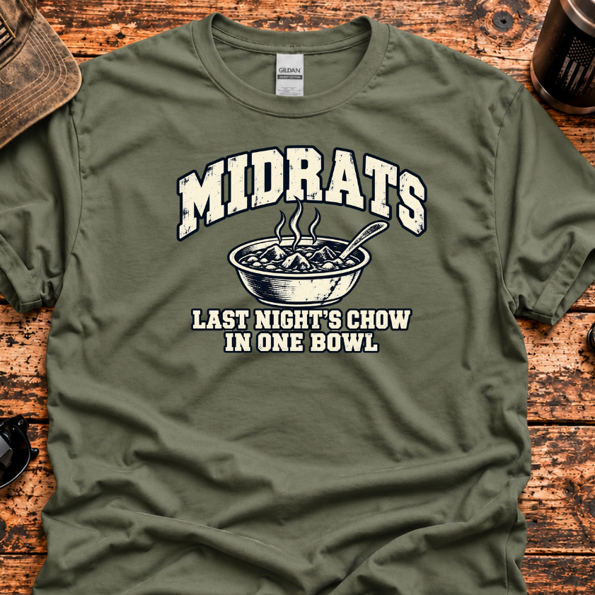 An olive green graphic t-shirt laid flat on a rustic wooden surface, surrounded by lifestyle props like a baseball cap, sunglasses, a mug, and a knife. The t-shirt features a distressed white graphic that reads 'MIDRATS' above an illustration of a bowl of food, with the text 'LAST NIGHT'S CHOW IN ONE BOWL' below.